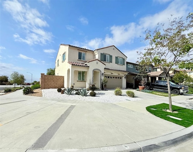 view of front of home with stucco siding, driveway, an attached garage, and a tile roof