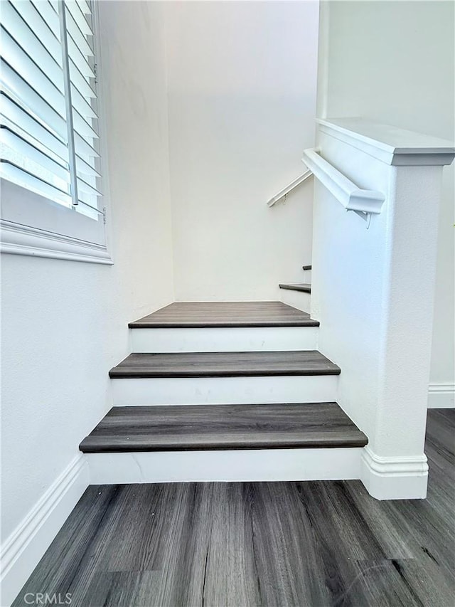 stairs with wood finished floors and baseboards