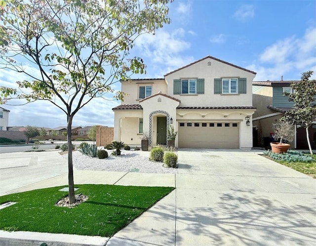 mediterranean / spanish-style house with driveway, a garage, stucco siding, and a tiled roof
