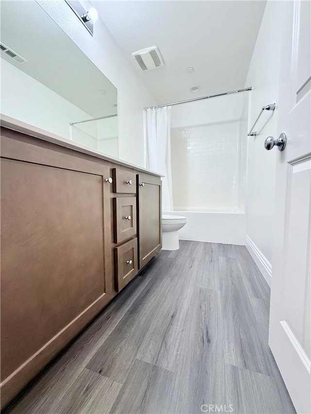 full bathroom with toilet, shower / bath combo, visible vents, and wood finished floors