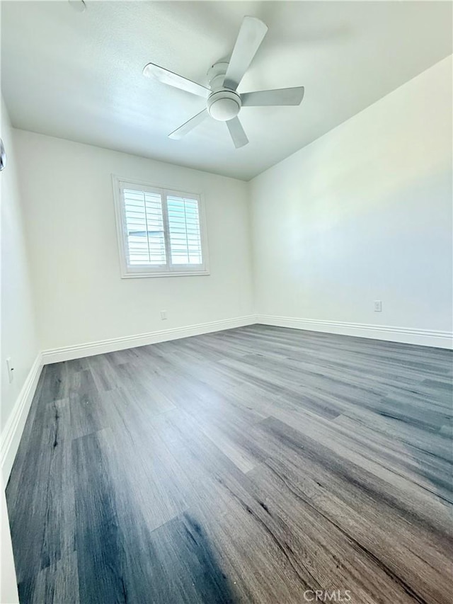 empty room with wood finished floors, ceiling fan, and baseboards