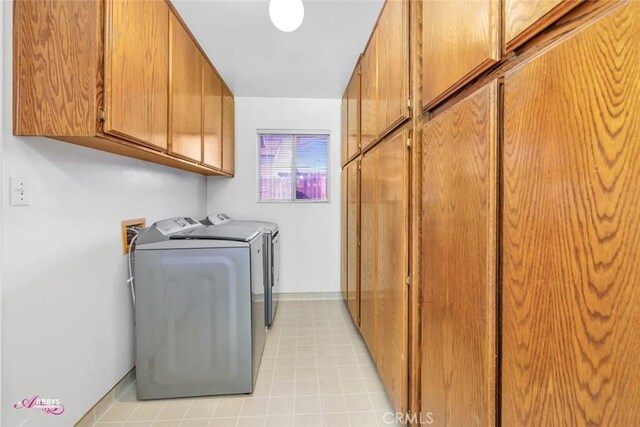 laundry room with independent washer and dryer and cabinet space
