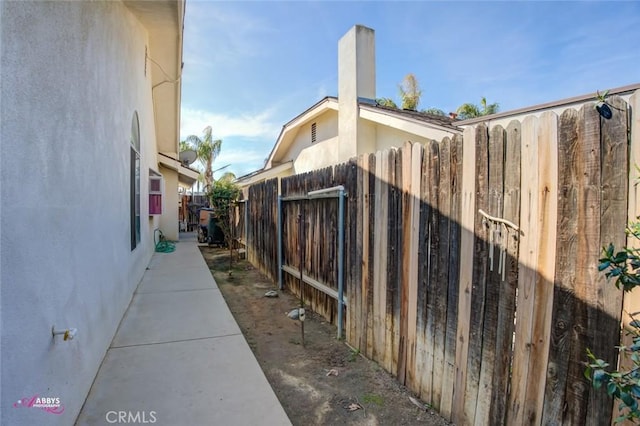 view of side of property featuring stucco siding and fence
