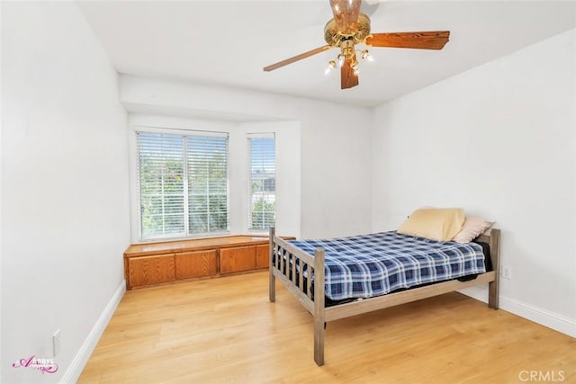 bedroom featuring a ceiling fan, baseboards, and light wood finished floors