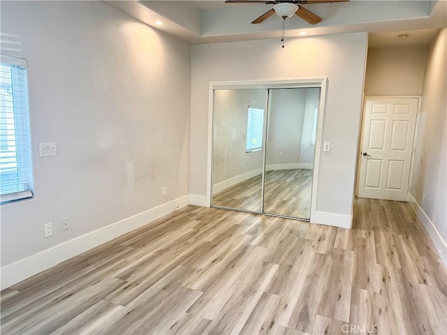 unfurnished bedroom featuring baseboards, a closet, recessed lighting, and light wood-style floors