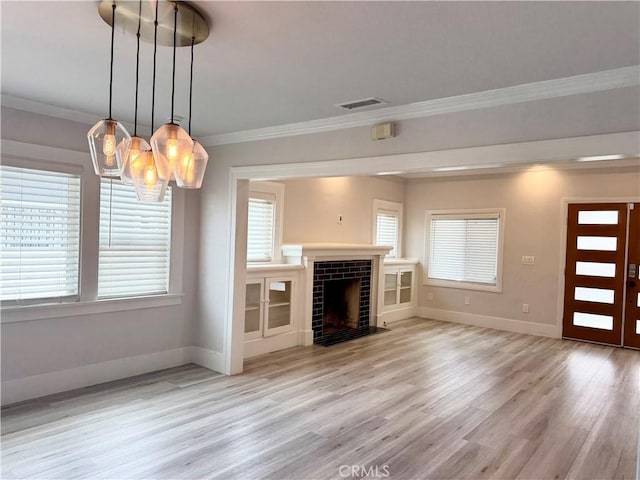 unfurnished living room featuring a notable chandelier, light wood finished floors, baseboards, visible vents, and ornamental molding