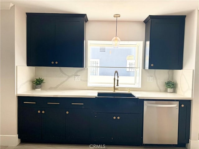 kitchen with a sink, tasteful backsplash, blue cabinetry, and dishwasher
