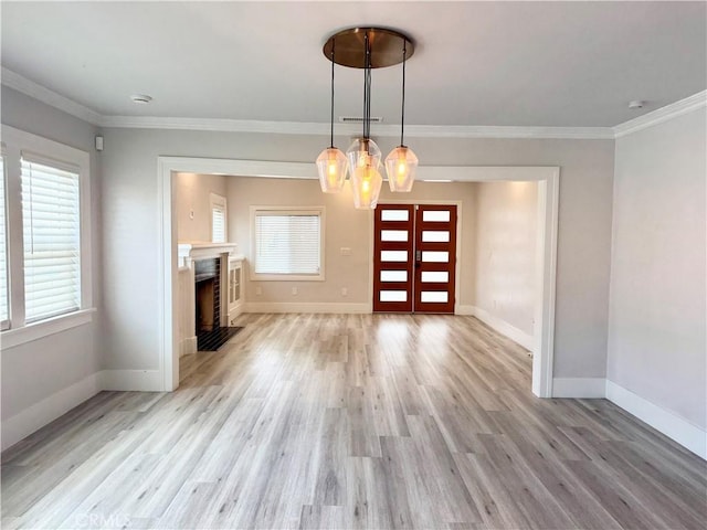 unfurnished dining area featuring visible vents, light wood finished floors, baseboards, ornamental molding, and an inviting chandelier