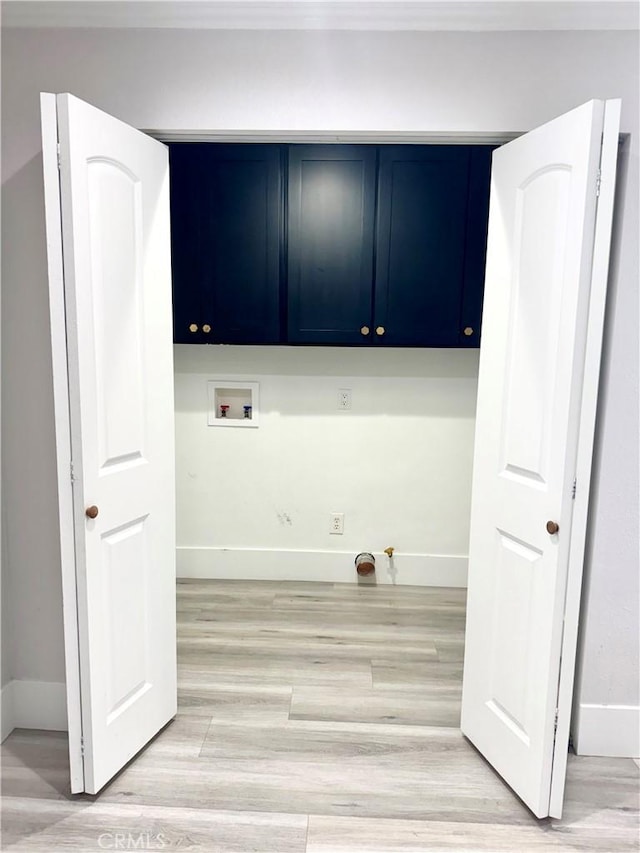 laundry area featuring cabinet space, hookup for a washing machine, light wood-style floors, and baseboards