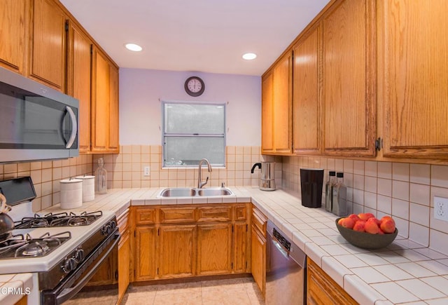 4558 Jessica Dr, Los Angeles, CA 90065 - kitchen with decorative backsplash, tile countertops, appliances with stainless steel finishes, brown cabinets, and a sink