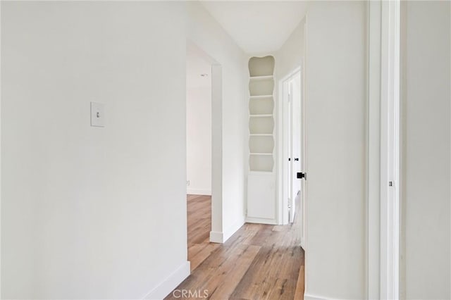 hallway featuring baseboards and light wood-style floors