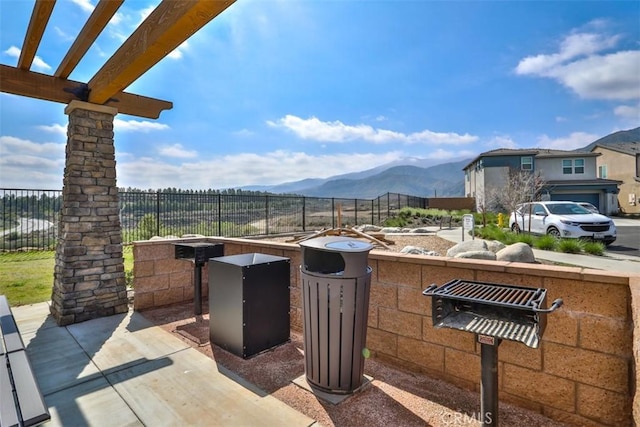 view of patio with a mountain view and fence