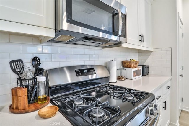 kitchen featuring backsplash, white cabinetry, stainless steel appliances, and light countertops