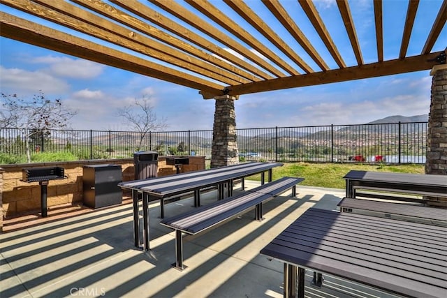 view of patio / terrace featuring a fenced backyard, a mountain view, and outdoor dining area