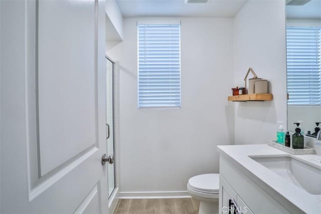 24307 Juni Ct, Corona, CA 92883 - bathroom with vanity, a stall shower, wood finished floors, toilet, and baseboards