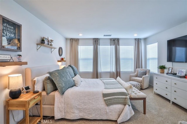bedroom with visible vents and light carpet