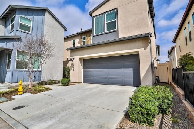 view of front facade featuring concrete driveway, a garage, stucco siding, and fence