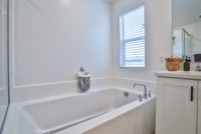 full bathroom with a bath, a wealth of natural light, vanity, and a stall shower