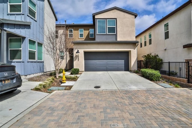 traditional-style home with driveway, a garage, stucco siding, and fence