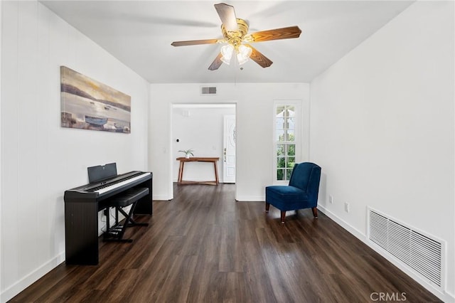 living area with visible vents, dark wood finished floors, and ceiling fan
