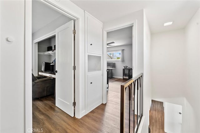 hallway with an upstairs landing and wood finished floors