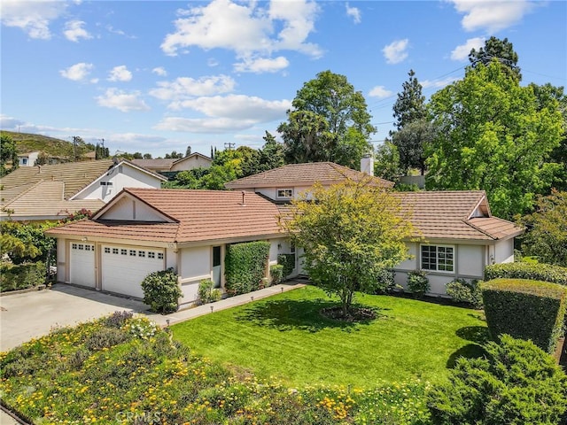single story home with a tile roof, a garage, stucco siding, a front yard, and concrete driveway