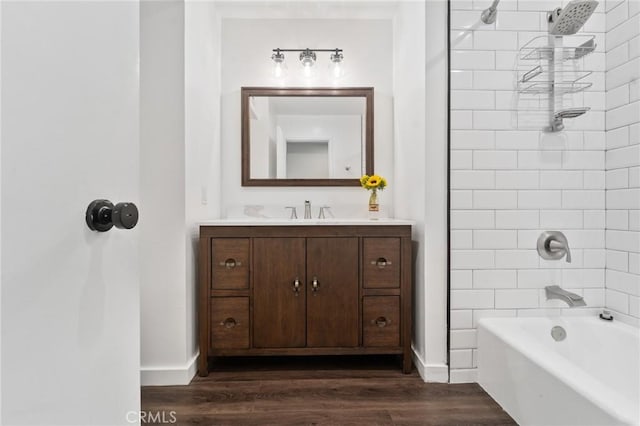 bathroom with vanity, baseboards, shower / tub combination, and wood finished floors