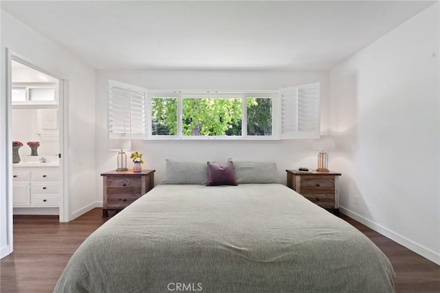 bedroom featuring connected bathroom, baseboards, and dark wood-style floors