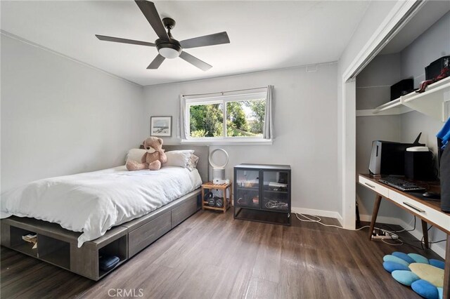 bedroom featuring baseboards, ceiling fan, a closet, and wood finished floors