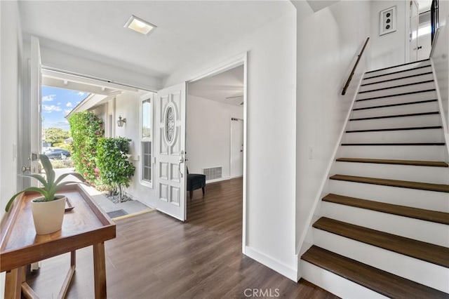 staircase featuring baseboards and wood finished floors