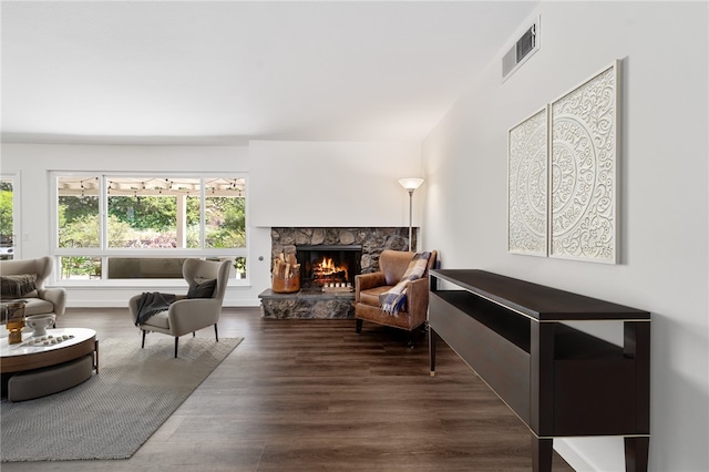 living room with a fireplace, wood finished floors, and visible vents