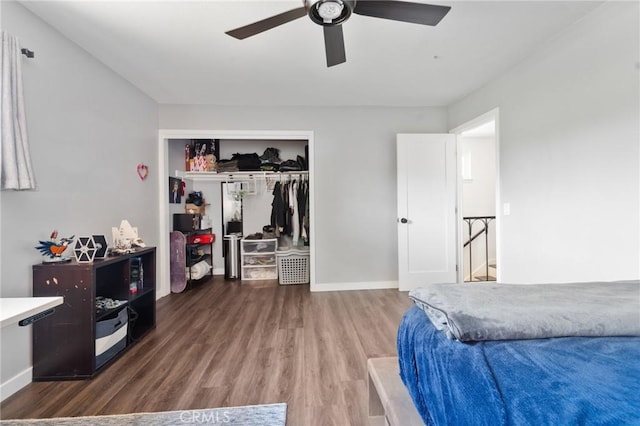 bedroom with baseboards, ceiling fan, wood finished floors, and a closet