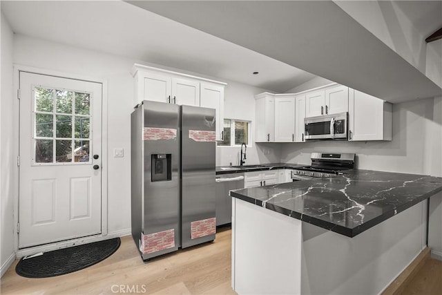 23817 Crest Forest Dr, Crestline, CA 92325 - kitchen featuring white cabinets, stainless steel appliances, light wood-style flooring, and a peninsula