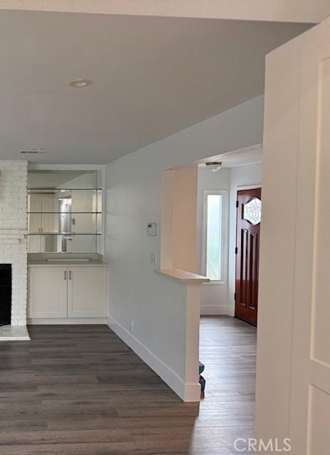 13305 Cordary Ave, Hawthorne, CA 90250 - kitchen featuring dark wood-type flooring, a brick fireplace, white cabinetry, and light countertops