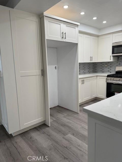 13305 Cordary Ave, Hawthorne, CA 90250 - kitchen featuring stainless steel appliances, light wood-style flooring, white cabinetry, tasteful backsplash, and recessed lighting