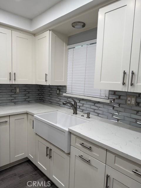 13305 Cordary Ave, Hawthorne, CA 90250 - kitchen featuring decorative backsplash, white cabinets, light stone counters, and dark wood finished floors