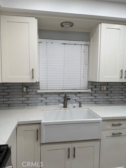 13305 Cordary Ave, Hawthorne, CA 90250 - kitchen with decorative backsplash, white cabinets, light stone countertops, and range