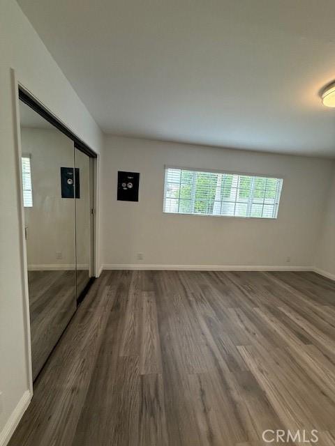 13305 Cordary Ave, Hawthorne, CA 90250 - unfurnished bedroom featuring dark wood-style floors, multiple windows, and a closet