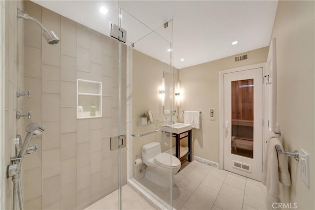 full bathroom featuring visible vents, tile patterned floors, toilet, and a shower stall