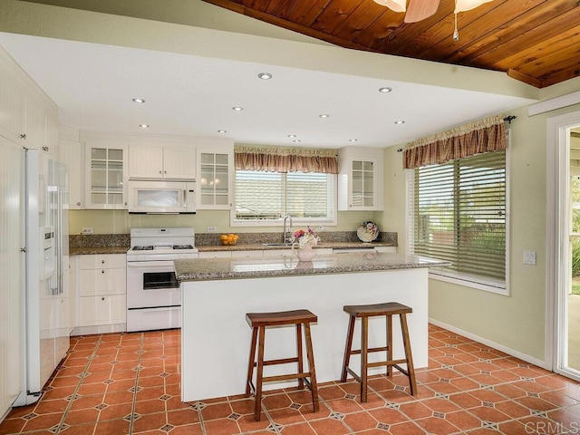 950 E Elder St, Fallbrook, CA 92028 - kitchen featuring white appliances, a sink, a center island, a breakfast bar, and white cabinets