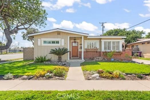 bungalow-style home featuring brick siding and a front yard