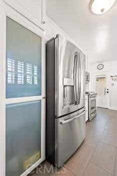 kitchen featuring white cabinets, tile patterned flooring, and stainless steel appliances