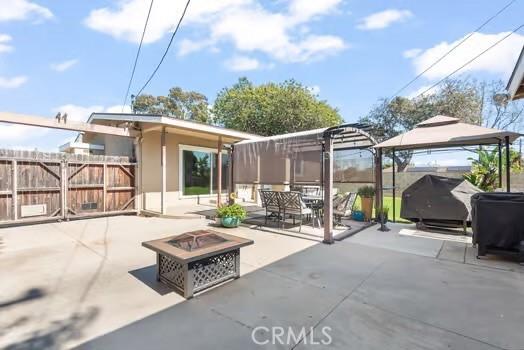 view of patio / terrace featuring a grill, an outdoor fire pit, a gazebo, and fence