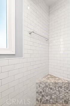 full bath featuring a tile shower and tile walls