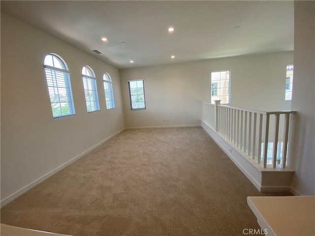 spare room with baseboards, visible vents, recessed lighting, and carpet