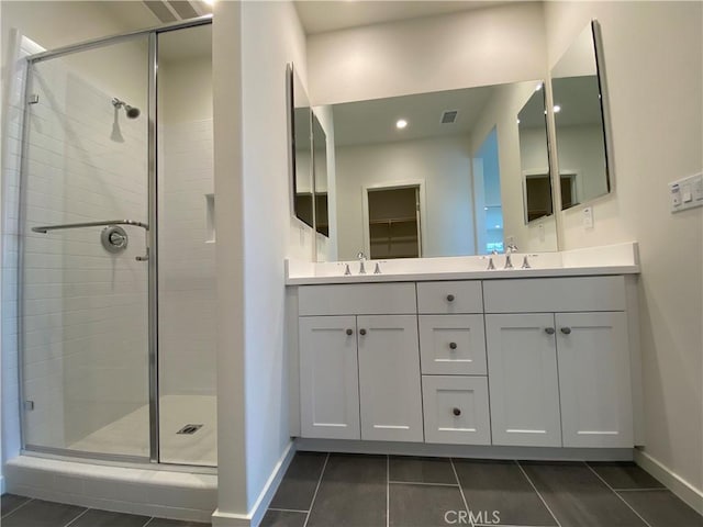 full bath with visible vents, a sink, baseboards, and a shower stall