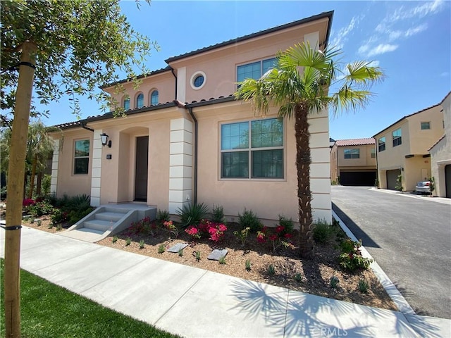 mediterranean / spanish home with stucco siding and a tiled roof