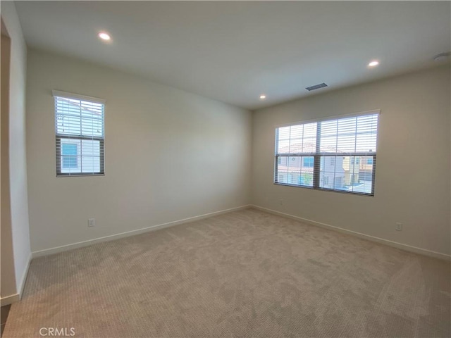 spare room featuring light carpet, baseboards, visible vents, and recessed lighting