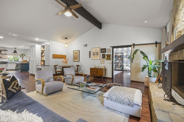 living area featuring beam ceiling, a barn door, recessed lighting, a ceiling fan, and wood finished floors