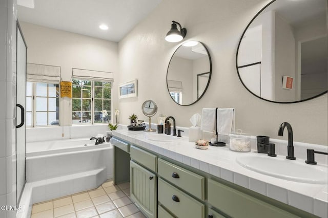 bathroom with a garden tub, tile patterned floors, a sink, and double vanity